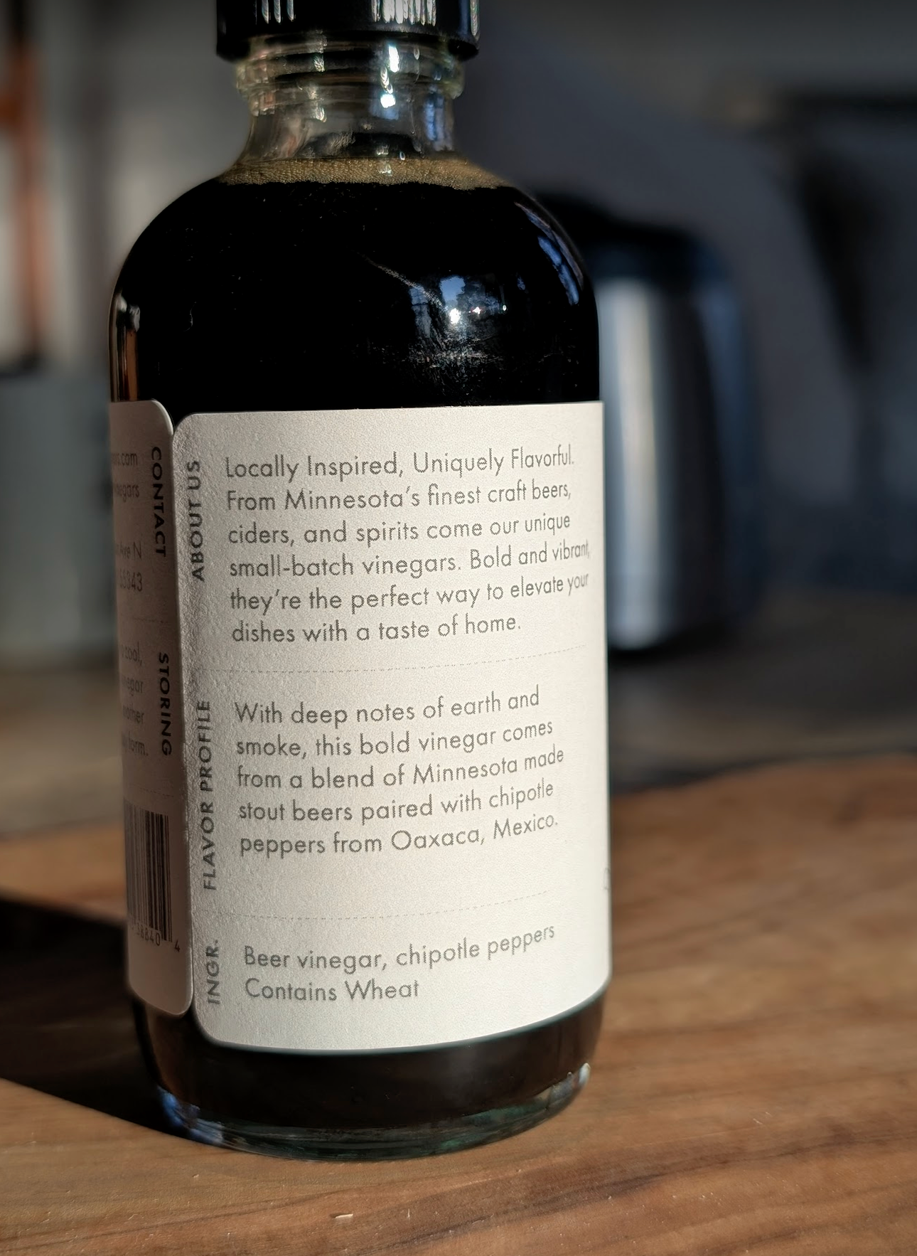 Bottle of beer vinegar with a label on a wooden surface