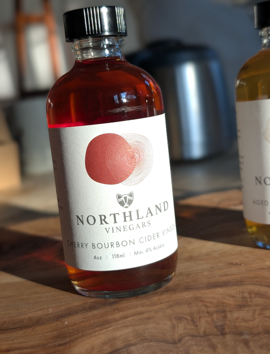 Bottle of Northland Vinegars Cherry Bourbon Cider Vinegar with rich cherry and oaky bourbon notes, handcrafted in Minnesota.